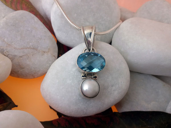 Colgante artesanal de plata y un conjunto de Topacio azul facetatado con una perla natural.. Foto 1